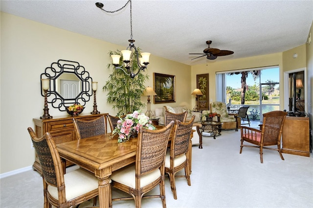 carpeted dining area with ceiling fan with notable chandelier and a textured ceiling