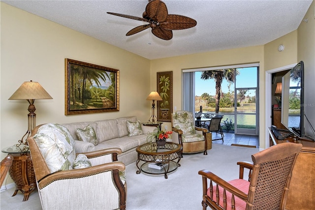 living room featuring ceiling fan, carpet floors, and a textured ceiling