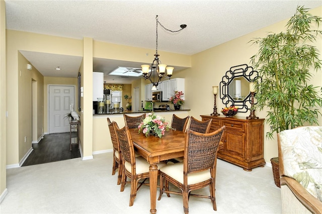 carpeted dining space with an inviting chandelier and a textured ceiling