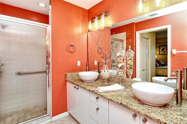 bathroom featuring tile patterned floors, vanity, and a shower with shower door