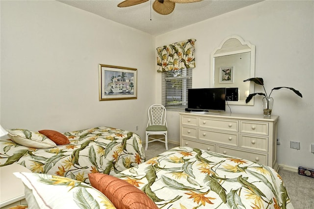 bedroom with ceiling fan, light carpet, and a textured ceiling