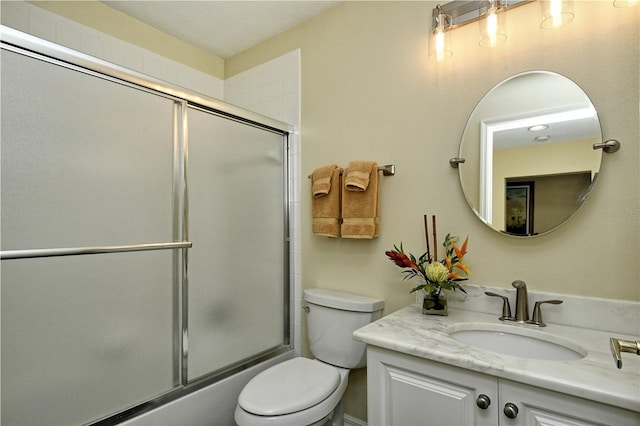 full bathroom featuring enclosed tub / shower combo, vanity, and toilet