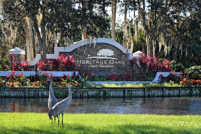 community sign featuring a water view