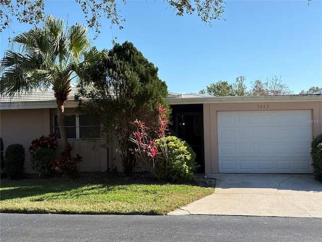 single story home featuring a garage and a front lawn