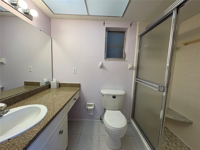 bathroom featuring vanity, tile patterned floors, toilet, and walk in shower