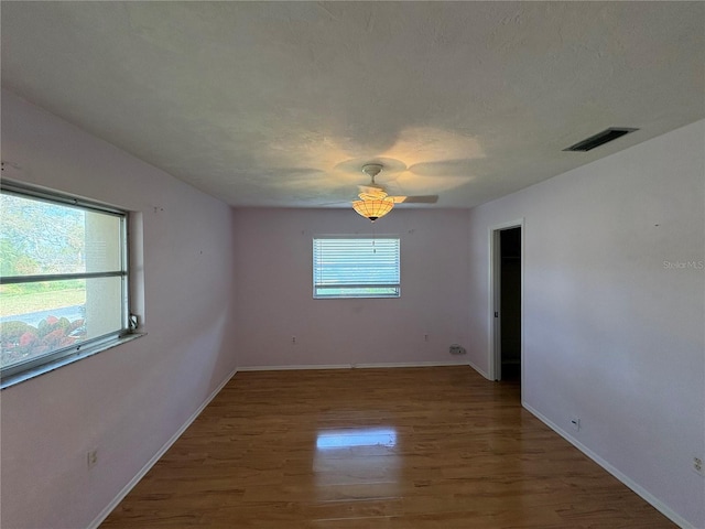 spare room with ceiling fan, hardwood / wood-style floors, and a textured ceiling