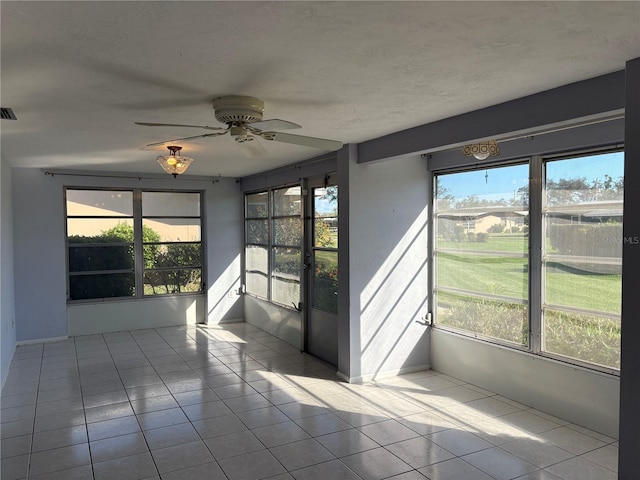 unfurnished sunroom with ceiling fan and a wealth of natural light