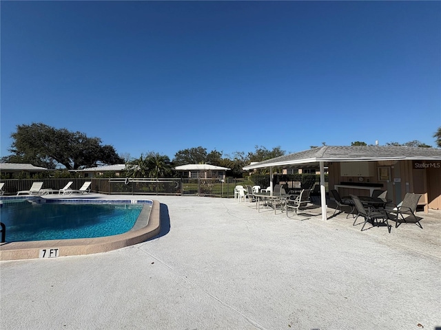 view of pool with a patio and an outdoor bar