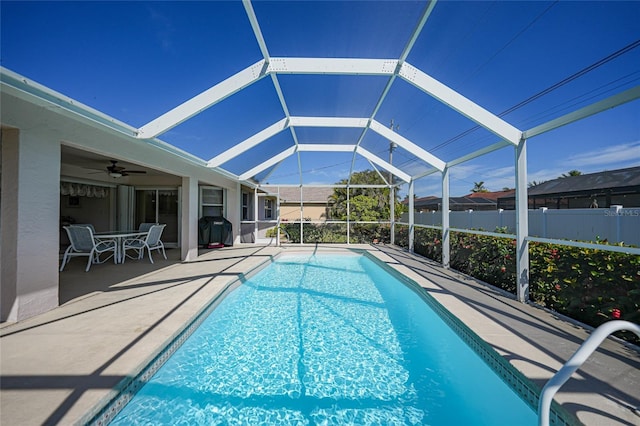 view of pool featuring ceiling fan, a grill, a lanai, and a patio area