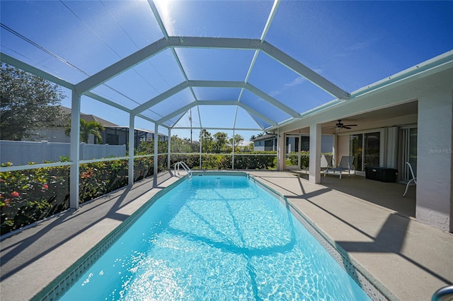 view of swimming pool featuring ceiling fan, a patio, and glass enclosure