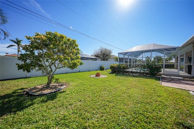 view of yard with a patio, a lanai, and a fire pit