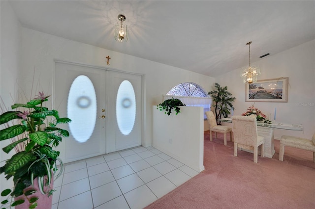 carpeted entryway with vaulted ceiling, a notable chandelier, and french doors