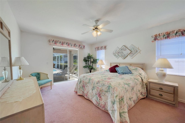 carpeted bedroom featuring multiple windows, access to exterior, and ceiling fan