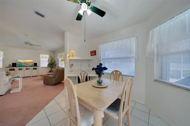 dining area featuring ceiling fan and light colored carpet