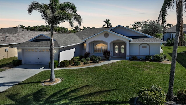 ranch-style house with a garage and a lawn