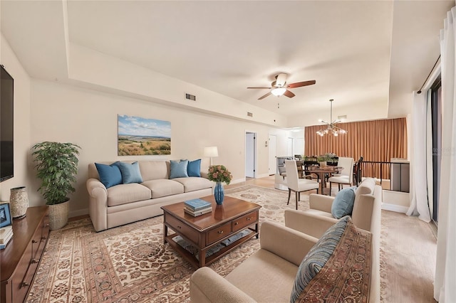 living room featuring ceiling fan with notable chandelier