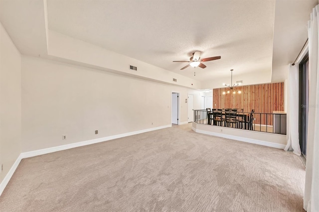 unfurnished living room featuring carpet, ceiling fan with notable chandelier, and a textured ceiling