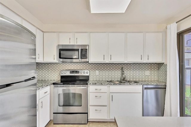 kitchen featuring sink, white cabinetry, tasteful backsplash, stainless steel appliances, and light stone countertops