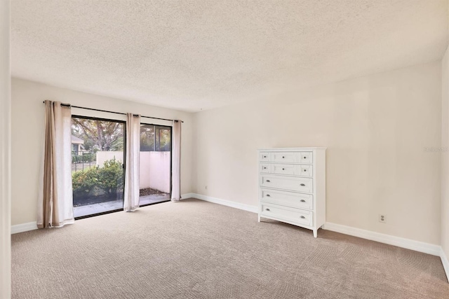 carpeted spare room with a textured ceiling