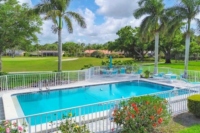 view of swimming pool featuring a patio and a yard