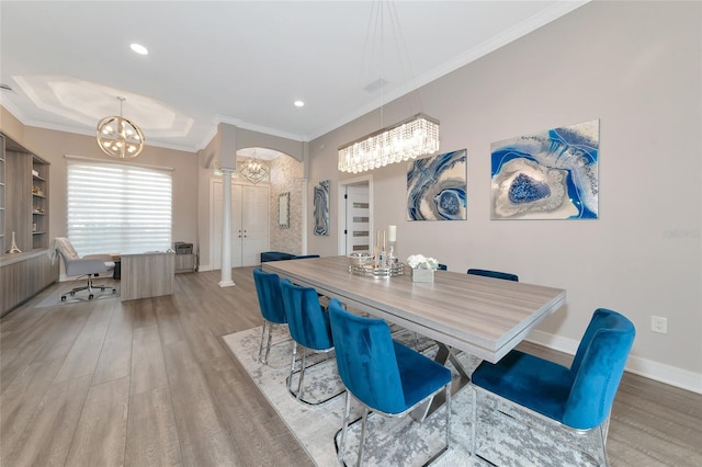 dining space with crown molding, an inviting chandelier, and hardwood / wood-style floors