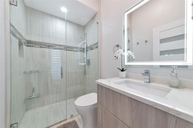 bathroom featuring vanity, an enclosed shower, and toilet