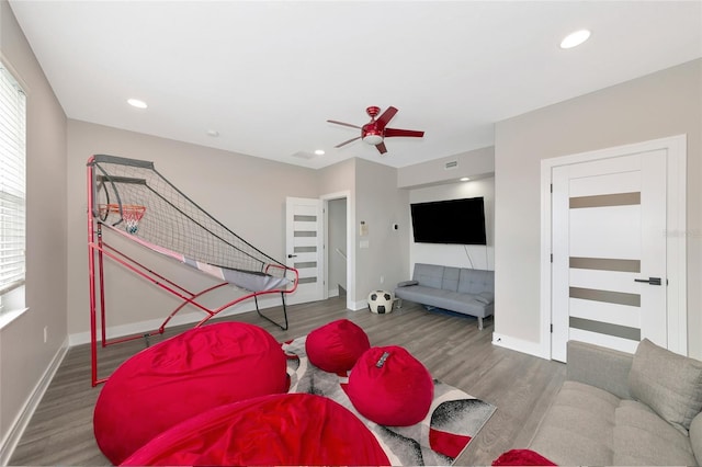 living room featuring ceiling fan, plenty of natural light, and dark hardwood / wood-style floors