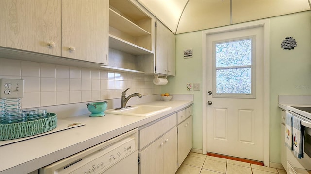 kitchen with light tile patterned flooring, sink, backsplash, and white appliances