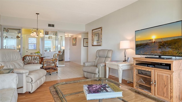 living room featuring a notable chandelier and light hardwood / wood-style flooring