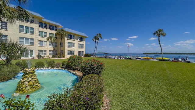 view of swimming pool with a lawn and a water view