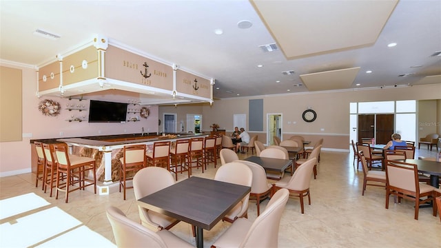 dining area featuring crown molding and light tile patterned floors