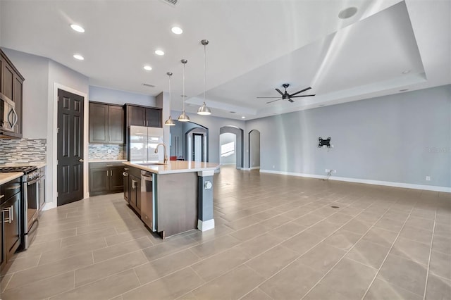 kitchen featuring dark brown cabinetry, appliances with stainless steel finishes, sink, and an island with sink