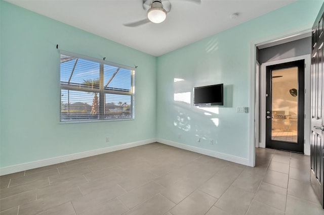 spare room with ceiling fan and light tile patterned floors