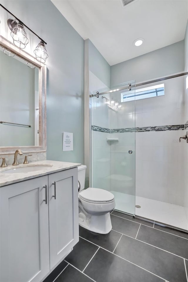 bathroom featuring walk in shower, tile patterned floors, toilet, and vanity