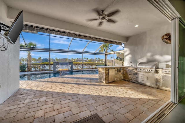 view of patio with pool water feature, sink, a water view, grilling area, and exterior kitchen