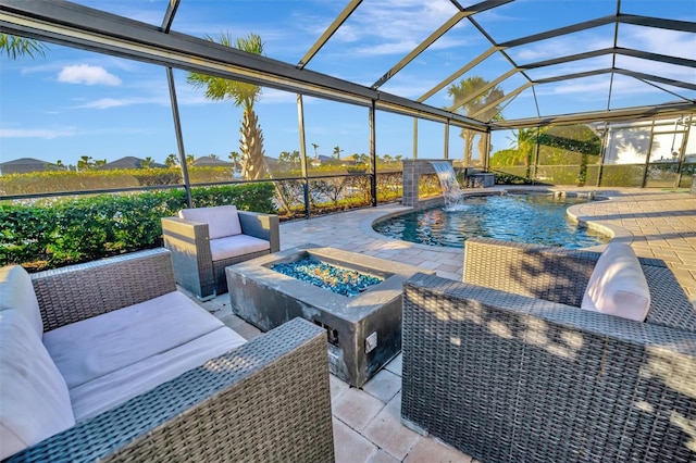 view of swimming pool featuring a patio, an outdoor living space with a fire pit, pool water feature, and glass enclosure