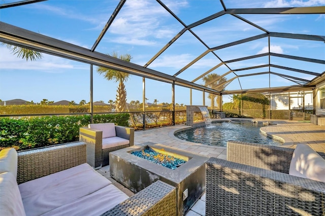 view of pool featuring pool water feature, a lanai, a patio area, and a fire pit