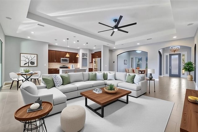 5607 Tidewater Preserve Blvd, Bradenton, FL 34208 - living room featuring arched walkways, a raised ceiling, recessed lighting, and a ceiling fan