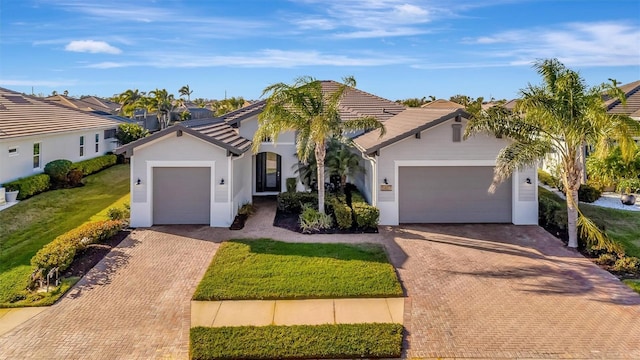 5607 Tidewater Preserve Blvd, Bradenton, FL 34208 - ranch-style house featuring decorative driveway, a garage, a tiled roof, and a front yard