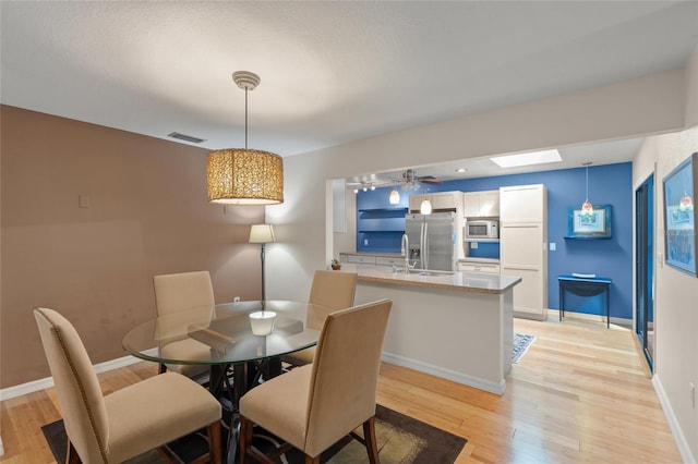 dining area featuring ceiling fan and light wood-type flooring