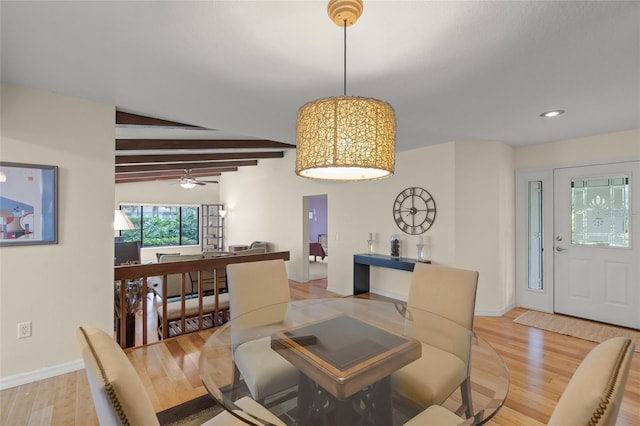 dining space with ceiling fan, lofted ceiling with beams, and light wood-type flooring