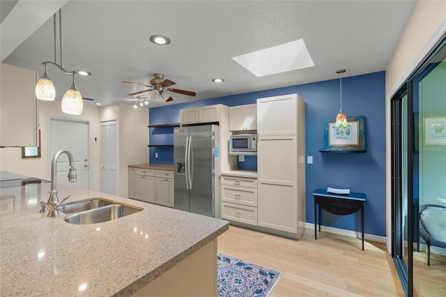 kitchen featuring hanging light fixtures, white cabinetry, appliances with stainless steel finishes, and sink