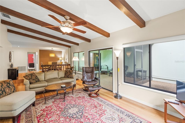 living room with ceiling fan, light hardwood / wood-style floors, and vaulted ceiling with beams