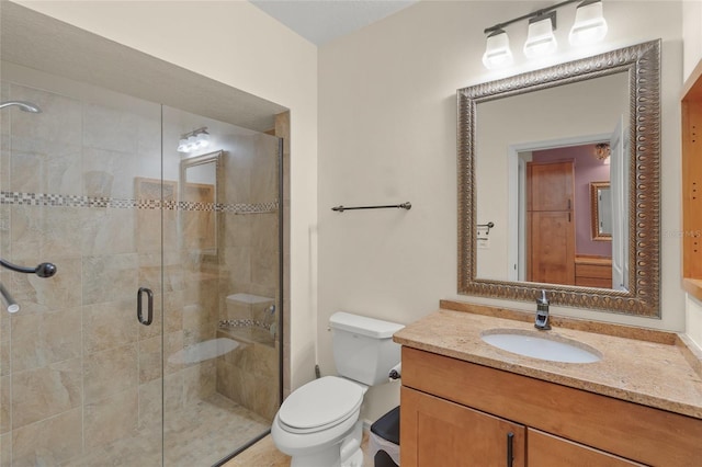 bathroom featuring an enclosed shower, vanity, and toilet