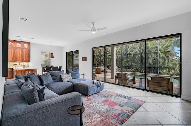 living room featuring light tile patterned floors, a wealth of natural light, and sink