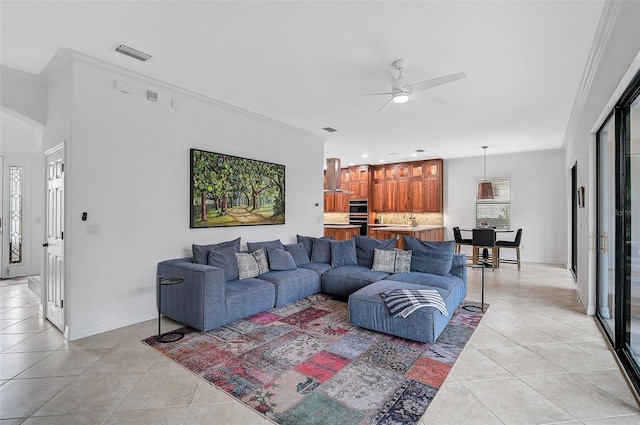 tiled living room with ceiling fan and ornamental molding