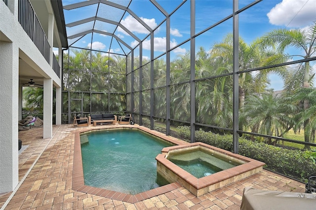 view of pool featuring a patio area, a lanai, an in ground hot tub, ceiling fan, and an outdoor living space