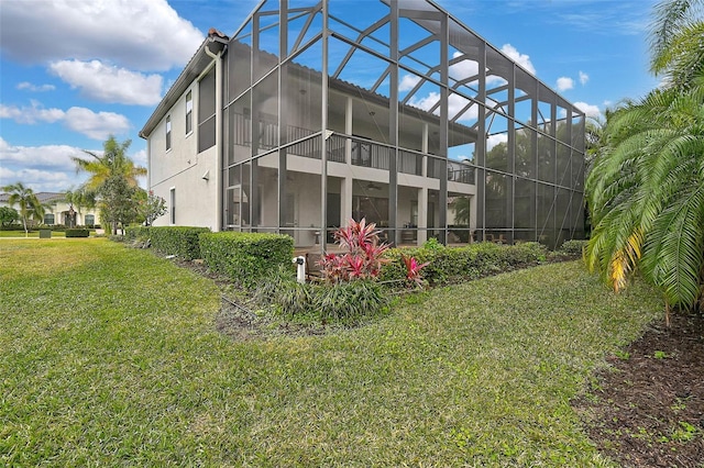 rear view of property with a lanai and a lawn