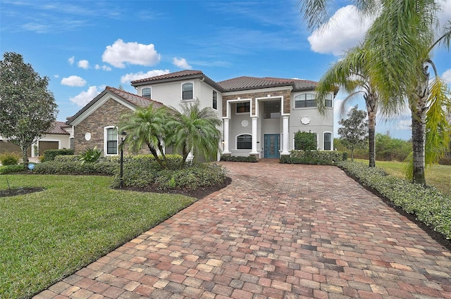 mediterranean / spanish house featuring a front lawn