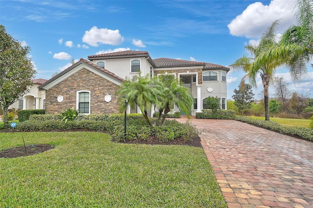 mediterranean / spanish home featuring a front lawn